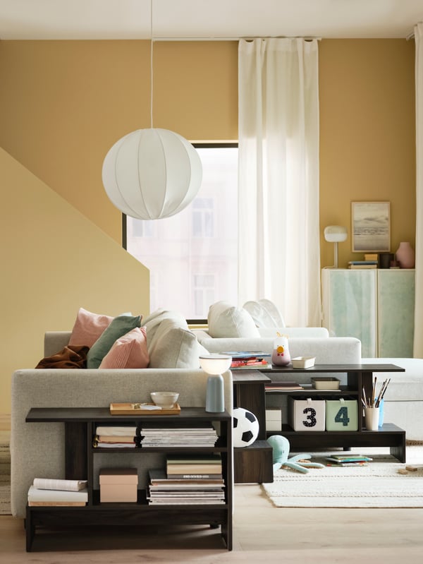 A REGNSKUR pendant lamp shade hangs above a beige VIMLE 2-seat sofa back-to-back with a VIMLE chaise longue in a bright room.