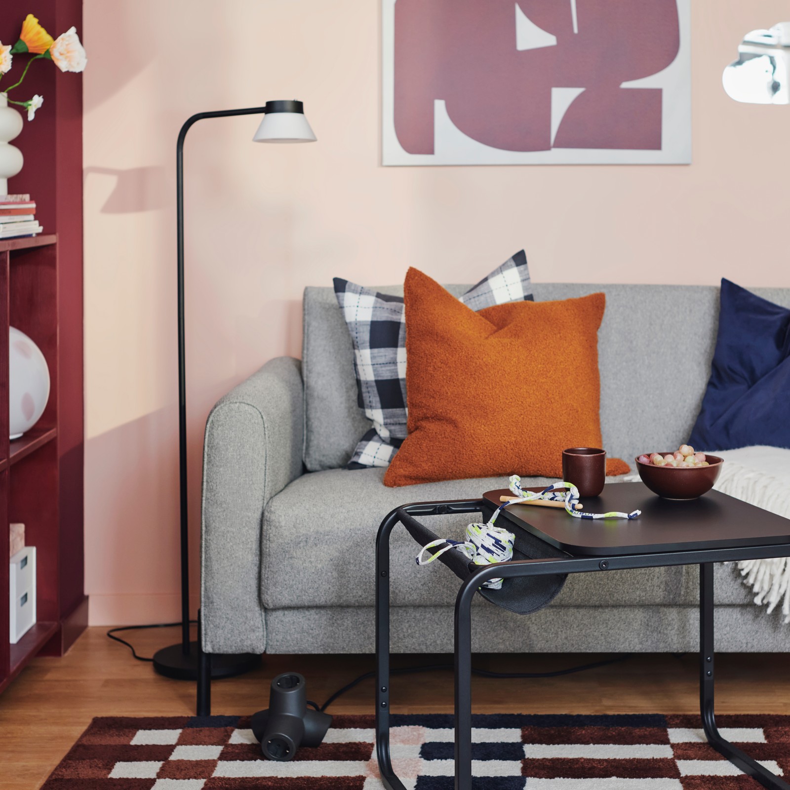 An OLSERÖD side table stands in front of a grey-beige SALTMYRAN 2-seat sofa with some extra cushions on it.