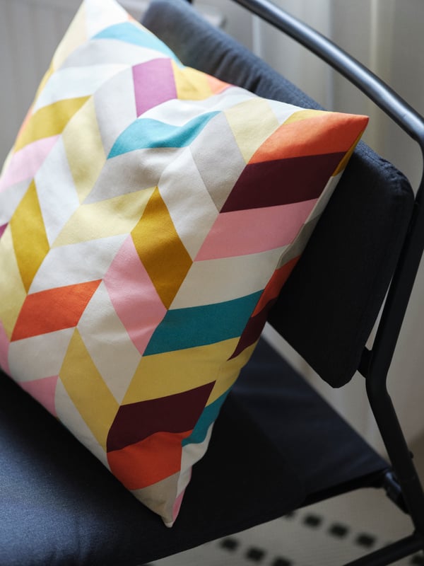 Multi-coloured HANNELISE cushion on a LINNEBÄCK lounge chair.