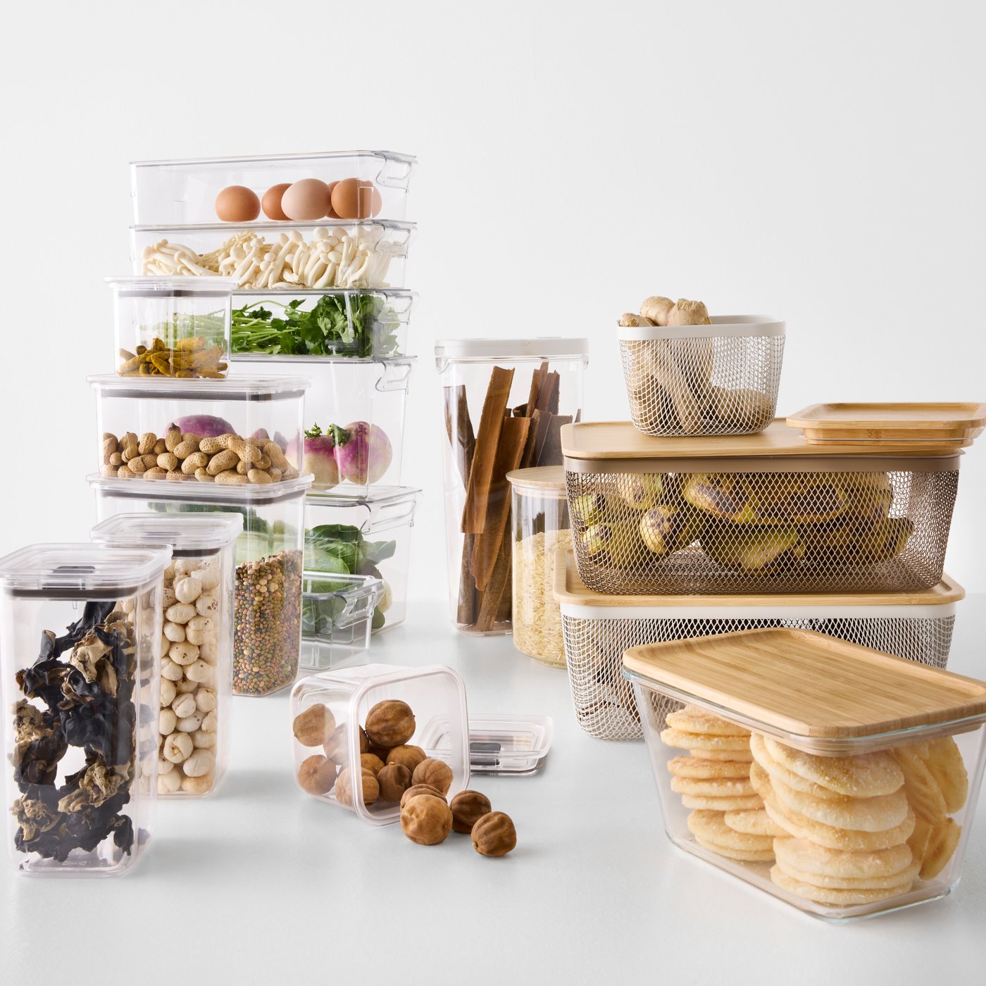 A white background with various IKEA 365+ food containers in rectangular glass and bamboo, neatly arranged on a countertop.