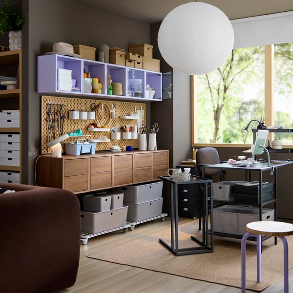 A workspace area by a window with multiple EKET wall cabinets in walnut effect featuring two drawers, next to a VITTSJÖ desk.