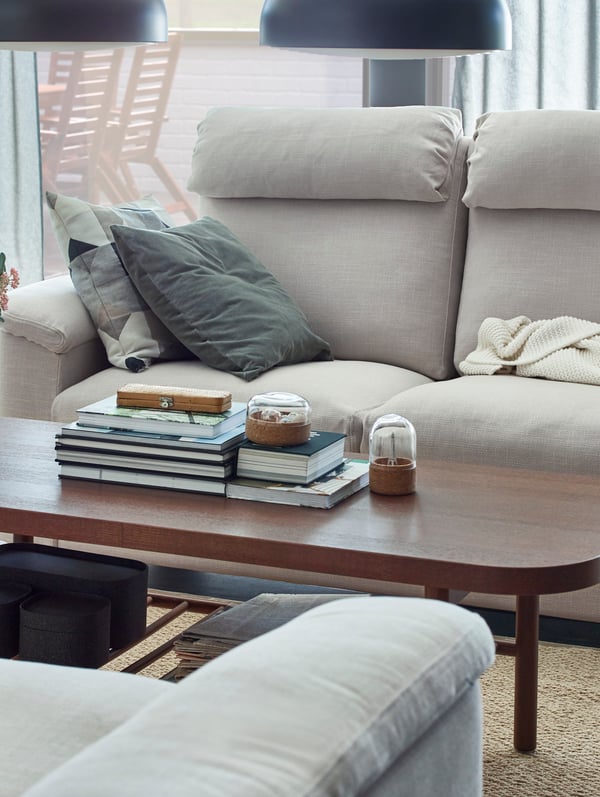 IKEA LIDHULT light beige sofas facing a dark brown coffee table.