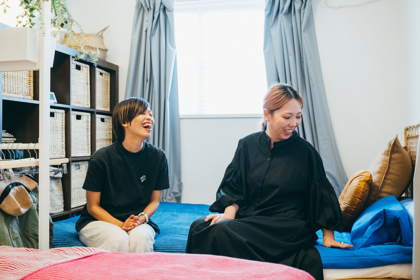 ベッドに腰を掛け、談笑する二人の人物