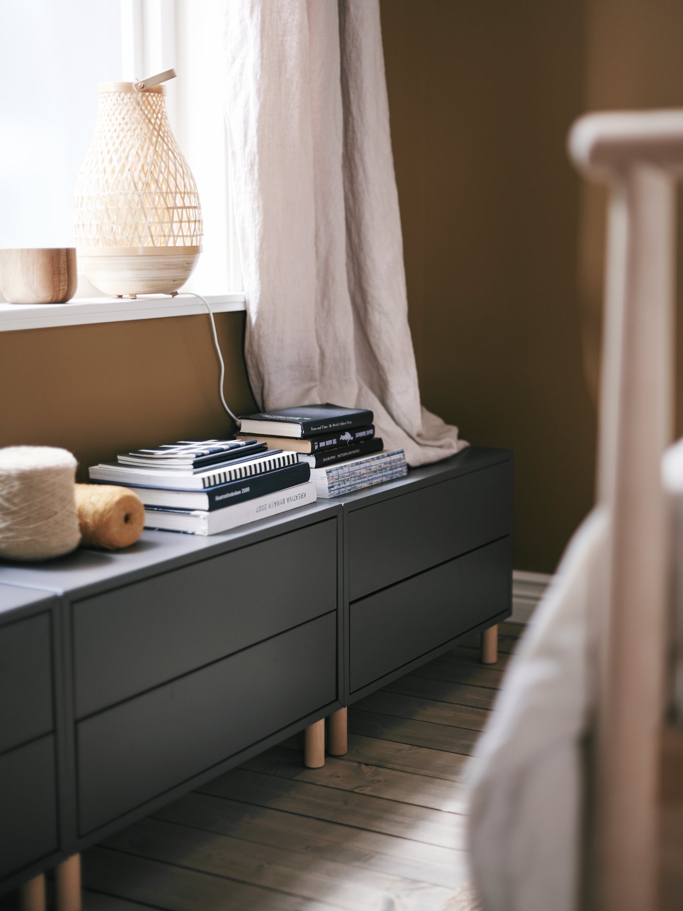 EKET cabinets with drawers and legs create storage space under a low bedroom window.