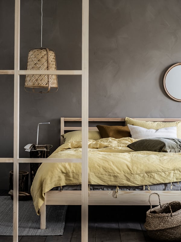 A bamboo/handmade KNIXHULT pendant lamp in the bedroom