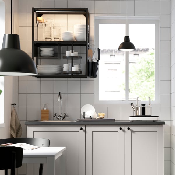 Vista frontal de una cocina con muebles ENHET cerrado con mesones de cocina gris. 