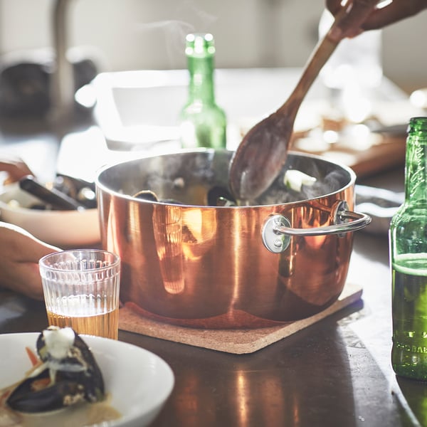 Una pentola FINMAT in rame e acciaio inossidabile con coperchio