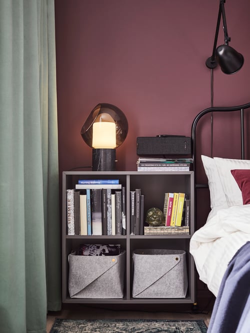 Bedroom with EKET cabinet, EVEDAL table lamp, SAGSTUA bed frame, SANELA curtains, SYMFONISK Wifi speaker, and SKURUP lamp.