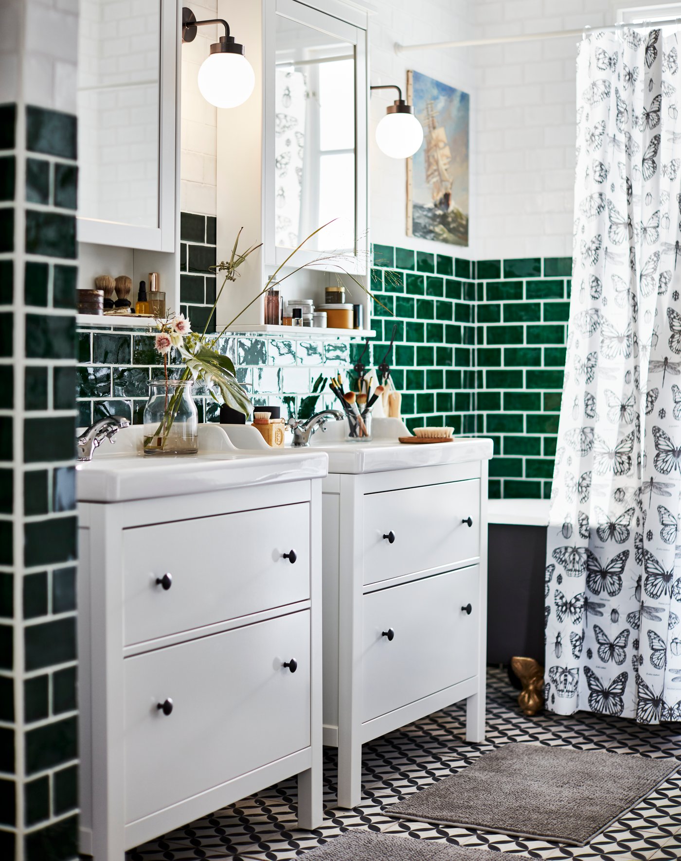 2 weiße HEMNES Waschtische vor einer grün gefließten Badezimmerwand. 