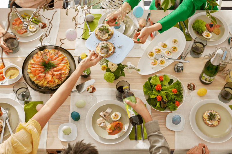 Table en bois clair rempli de vaisselles et de mets colorés