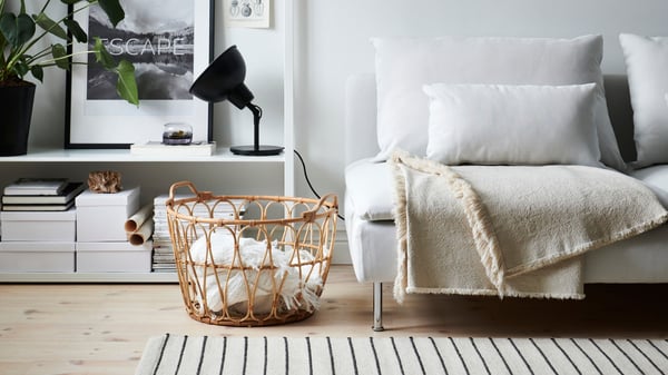In a living room in neutral colours, there is a SÖDERHAMN sofa with two cushions on it.