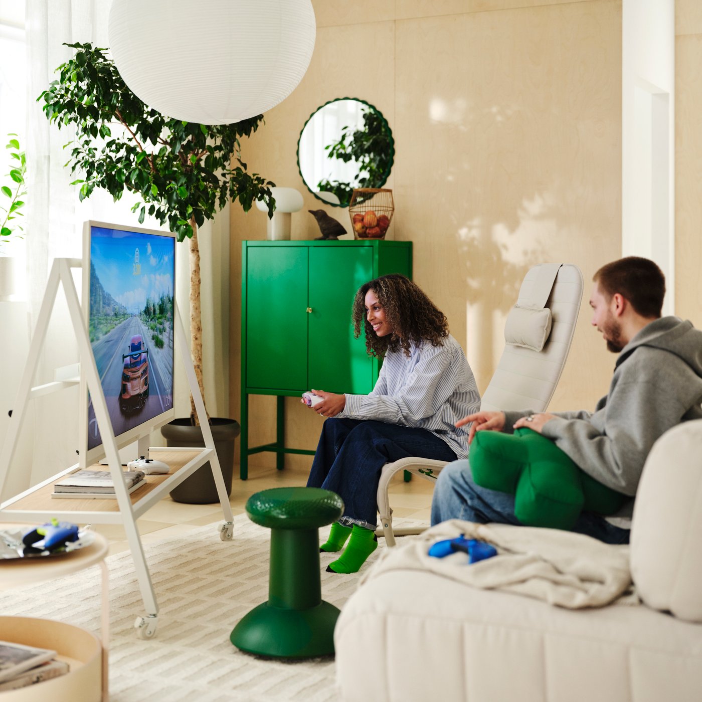 A couple is gaming in the living room surrounded by products from the YXSTABY collection.