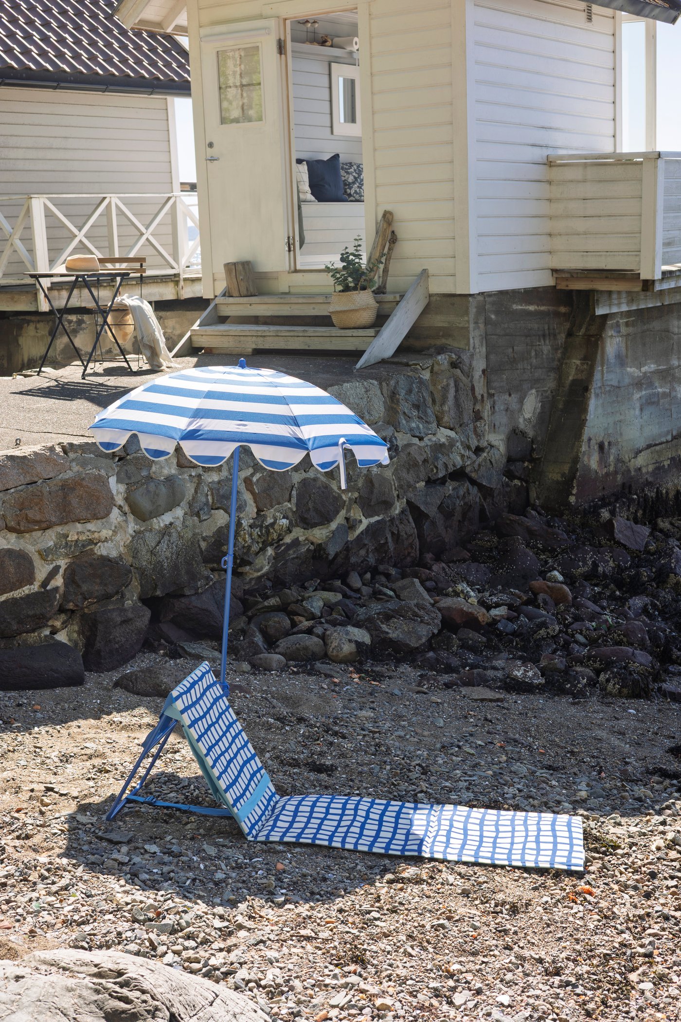 Parasoll og solseng på stranden.