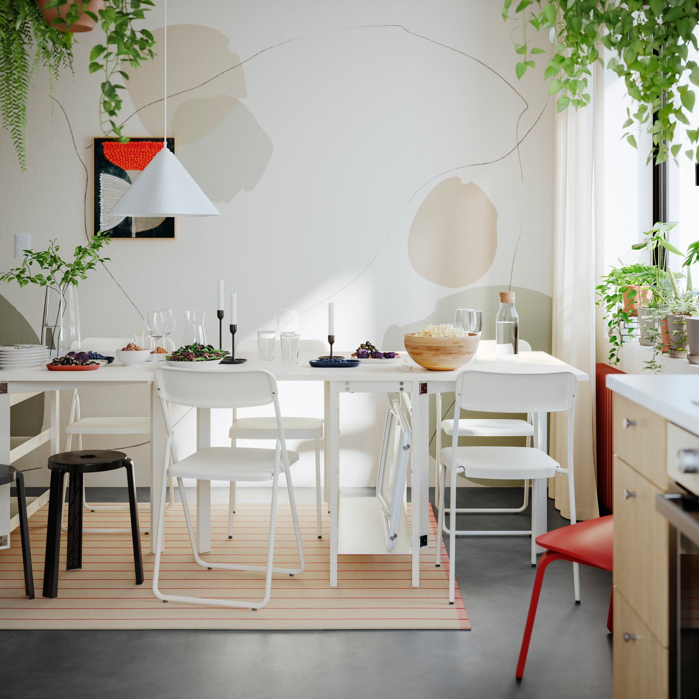 A bright dining area featuring a white dining table surrounded by chairs, plants, and a pendant lamp.