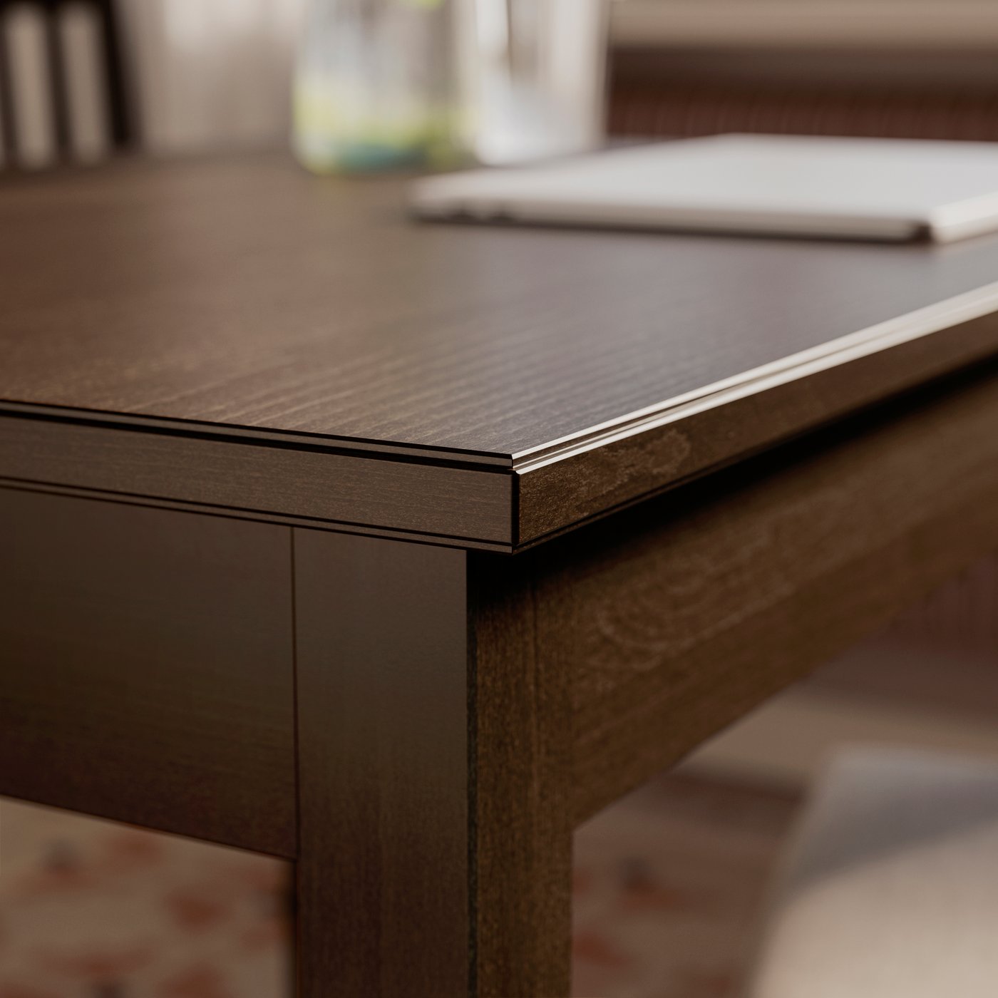 A close-up of one corner of a dark brown stained/beech veneer NÄSINGE extendable table.
