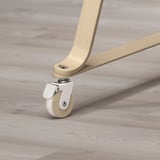 Close-up of bassinet wheel. White with wooden rim, attached to light wooden leg. Four wheels for mobility.