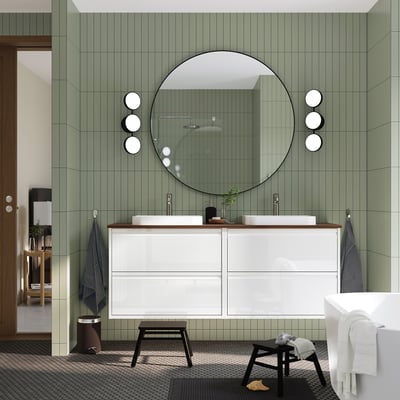 Modern white bathroom vanity, ÄNGSJÖN, with two sinks, large mirror, green tiles, and sleek finish.
