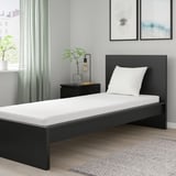 Bedroom: modern bed, nightstand with lamp & plant, rug, large window.