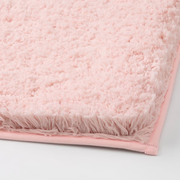 Close-up of soft pink bath mat, showing plush texture and sturdy edges.