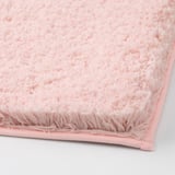 Close-up of soft pink bath mat, showing plush texture and sturdy edges.