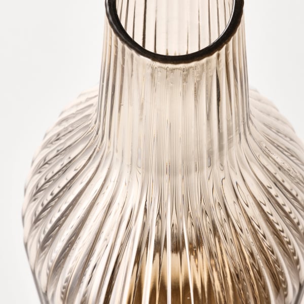 Clear glass carafe with vertical ridges, simple and elegant design, perfect for beverages or flowers.