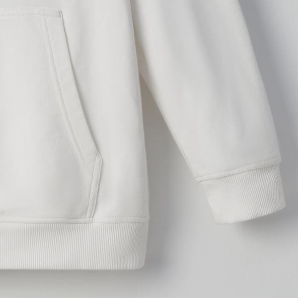 Close-up of hoodies pocket and sleeve, showcasing soft cotton texture and stitching detail.