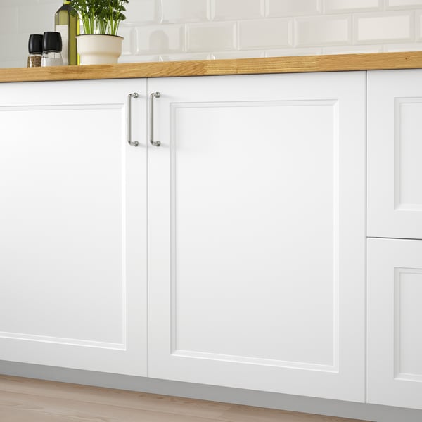 Clean white kitchen cabinets with wooden countertop, featuring AXSTAD door handles, displaying modern design.