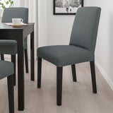Modern dining setup: grey BERGMUND chairs with wooden legs. Comfortable, covered seats, match dark table. Ideal for cozy meals.