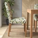 Upholstered chair with removable, washable floral cover, wooden legs, and comfortable seat padding. Perfect for dining.