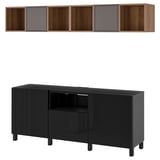 A black BESTÅ tv storage unit and a wall-mounted shelf with wooden compartments and purple sections.