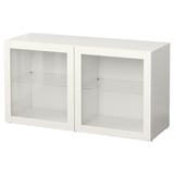 A white BESTÅ shelf unit with two glass doors and glass shelves.