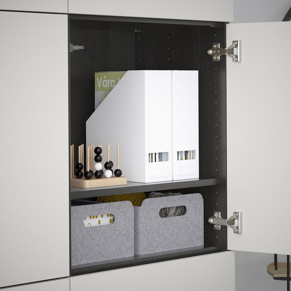 An open white cabinet with adjustable shelves, storage boxes, and decorative items.