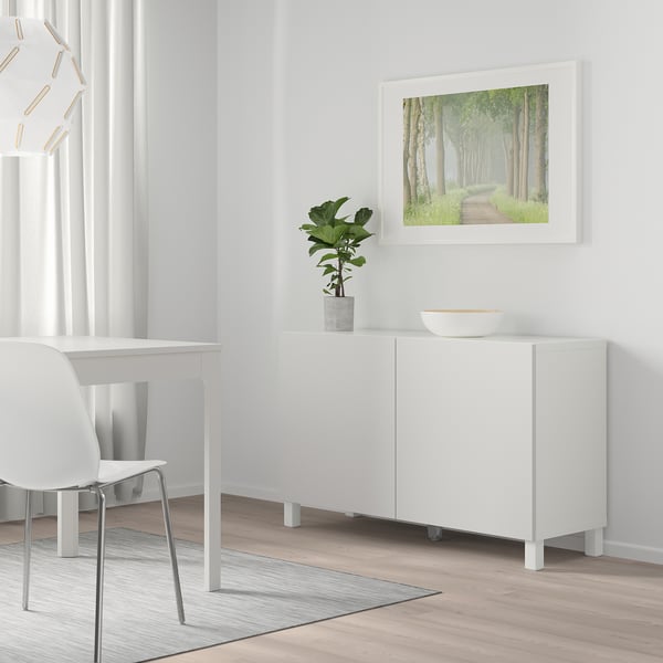 Modern BESTÅ sideboard with shelves, desk, chair, plant, and poster.