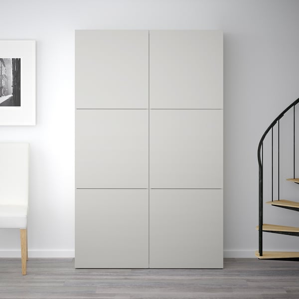 White BESTÅ cabinet with four doors, tall against wall, near spiral staircase and chair.