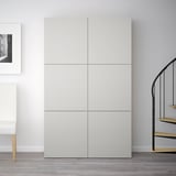 Modern white BESTÅ wardrobe, tall with clean lines, gray floor, white chair, black spiral staircase.