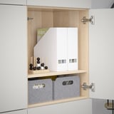 White cupboard with adjustable shelves, decorative top, two gray bins.