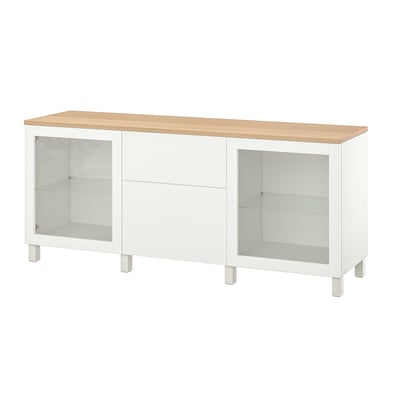 White BESTÅ sideboard, light wood top, glass doors, adjustable shelves.