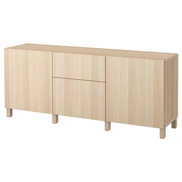 A light oak BESTÅ sideboard with four doors, two drawers, and wooden legs. Modern and minimalist design.