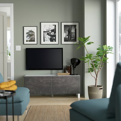 Modern living room: light green walls, BESTÅ tv bench, plant, blue armchair, coffee table.