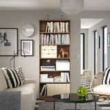 Living room with wooden bookcase, sofa, decor, and art.