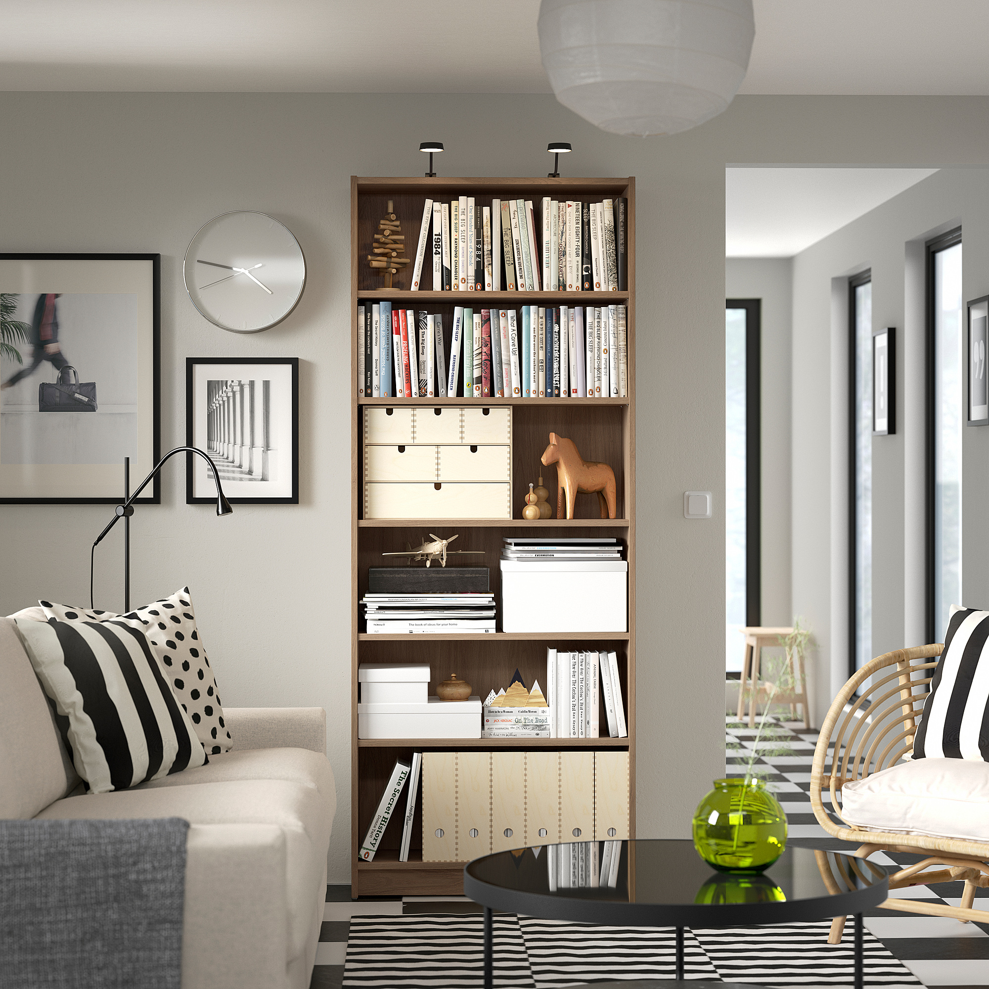 Living room with wooden bookcase, sofa, decor, and art.