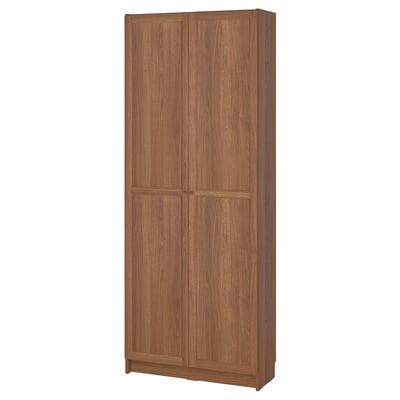 This image shows a BILLY bookcase with wooden doors, featuring a natural oak finish, rectangular shape, and adjustable shelves.