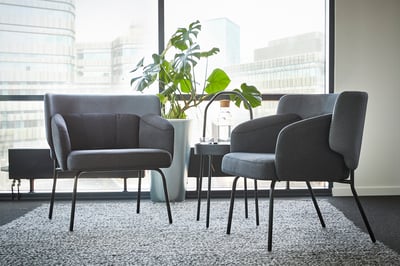 Modern office seating area with two gray BINGSTA chairs and a tall plant.