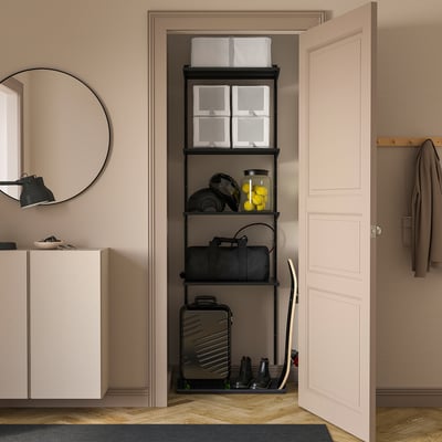 Black BOAXEL shelves in closet with boxes, sports gear, luggage, mirror, and coat rack.