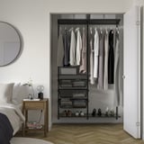 Open wardrobe: BOAXEL black metal, hanging clothes, shelves, and mesh baskets. Fits nicely in bedroom, organized, modern design.