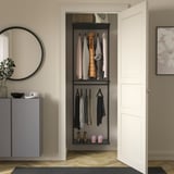 Wall-mounted BOAXEL storage system in dark grey, organizing clothes and shoes with open shelves and hanging rods.