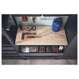 Bottom shelf with tools on a black workbench, featuring a wooden top.