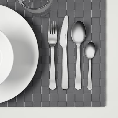 Stainless steel cutlery set on a grey placemat.