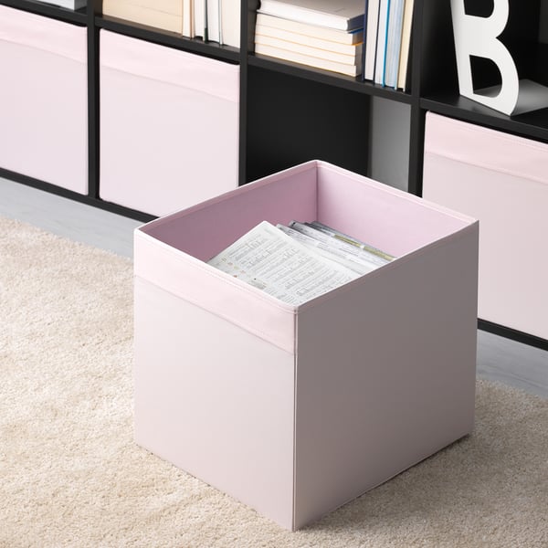 Beige storage boxes in fabric, one holding papers, in bookshelf. Perfect for organizing. Part of DRÖNA series for kallax.