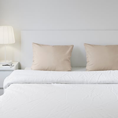 DVALA off-white pillowcases, two on a white bed, soft cotton, rectangular shape.